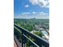 Enjoy city views from this balcony, showcasing a community pool and lush trees at 3481 Lakeside Ne Dr # 2303, Atlanta, GA 30326