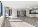 Bright and airy living room featuring wood floors, neutral walls, modern lighting, and a sliding glass door to a balcony at 3481 Lakeside Ne Dr # 2303, Atlanta, GA 30326