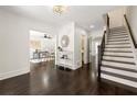 Bright foyer featuring dark wood floors, decorative mirror, and staircase at 320 Woodlake Ct, Alpharetta, GA 30005