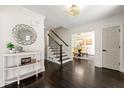 Bright foyer with dark wood floors, decorative mirror, and view of the dining room at 320 Woodlake Ct, Alpharetta, GA 30005