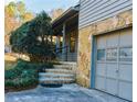 Stone steps leading up to the covered porch with metal railings and a one-car garage at 326 Rockland Way, Lawrenceville, GA 30046