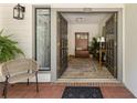 Open double doors reveal a welcoming foyer with decorative bench, rug and plants at 3772 Paces Ferry West Se, Atlanta, GA 30339
