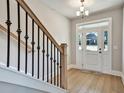 Bright entryway with hardwood floors, staircase with black iron railings, and a chandelier at 5272 Poplar Springs Rd, Stone Mountain, GA 30083