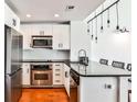 Modern kitchen features stainless steel appliances, granite countertops and wooden floors at 1261 Caroline St # 211, Atlanta, GA 30307