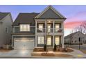 Charming two-story home with a welcoming front porch, gray siding and a two car garage at sunset at 800 Castile Ln, Woodstock, GA 30188