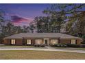 Charming brick home with a well-manicured lawn and mature trees at twilight at 3003 Hanover Se Ln, Conyers, GA 30094