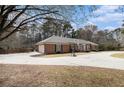 Brick home with an attached garage, basketball hoop, and circular driveway with space for recreation at 3003 Hanover Se Ln, Conyers, GA 30094