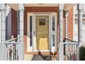 Inviting front entry showcasing a brick facade, decorative pillars, and a bright yellow door at 1902 Elm Park Dr, Hampton, GA 30228