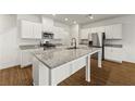 Modern kitchen showcasing granite counters, white cabinetry, and a central island with sink at 962 Edwin Ln, Sugar Hill, GA 30518