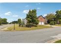 Landscaped corner lot home featuring a two-car garage, mature trees, and a well-maintained lawn at 4205 Idlewood Dr, Cumming, GA 30040
