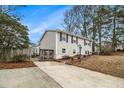 Inviting home featuring a spacious driveway, wooden fence, and mature trees at 6645 Doublegate Ln, Rex, GA 30273
