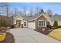 Inviting yellow home featuring a two-car garage and well-maintained front yard landscaping at 6775 Marlow Dr, Cumming, GA 30041