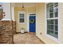 Cozy front porch with stone pillars and a vibrant blue front door with wreath at 6775 Marlow Dr, Cumming, GA 30041