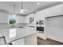 Bright kitchen featuring white cabinets, stainless steel appliances, large island, and pendant lighting at 1466 Auburn Glen Rd, Dacula, GA 30019
