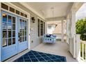 Charming front porch featuring a cozy porch swing and a blue diamond-patterned rug at 6755 Creek View Ln, Cumming, GA 30041