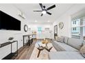 Bright, open-concept living room featuring a comfortable grey sofa, TV, and sleek ceiling fan at 1088 Wedgewood Nw Dr, Atlanta, GA 30318