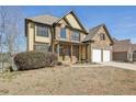 Charming two-story home with a stone and yellow siding exterior and a two-car garage at 70 Wentworth Ln, Villa Rica, GA 30180