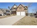 Charming two-story home with a stone and yellow siding exterior and a two-car garage at 70 Wentworth Ln, Villa Rica, GA 30180
