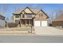 Charming two-story home with a stone and yellow siding exterior and a two-car garage at 70 Wentworth Ln, Villa Rica, GA 30180