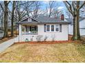 Charming bungalow featuring a covered front porch, painted brick facade, and well-maintained landscaping at 942 Byron Sw Dr, Atlanta, GA 30310