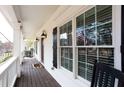 Inviting front porch featuring classic railings, sconce lighting, and a warm, wood-finished floor at 2800 Georgian W Dr, Brookhaven, GA 30341