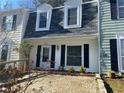 Charming townhome exterior with a black roof, black shutters, and stone paver front patio at 3228 Shadow Walk Ln, Tucker, GA 30084