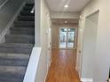 Inviting entry hallway with wood floors, freshly painted gray walls, and a carpeted staircase at 3228 Shadow Walk Ln, Tucker, GA 30084