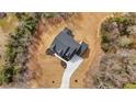 Aerial view of a home on a large lot surrounded by trees, featuring a dark shingle roof at 1629 Phillips Rd, Lithonia, GA 30058