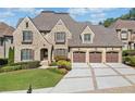 Beautiful brick home with a three-car garage, manicured lawn, and elegant landscaping at 1965 Carlotta Ct, Atlanta, GA 30345