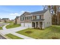 Attractive two-story home featuring a brick and siding exterior, three-car garage and green lawn at 5436 Flat Rock Point Pt, Stonecrest, GA 30038