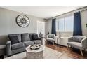 Comfortable living room with a gray couch, two gray chairs, decorative pillows, and a large clock on the wall at 215 Piedmont Ne Ave # 1804, Atlanta, GA 30308