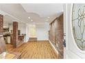 Open-concept living room features hardwood floors, a brick accent wall, and a glimpse of the modern kitchen at 869 Briarcliff Ne Rd # B25, Atlanta, GA 30306