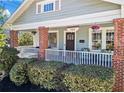 Inviting front porch with red brick pillars, white railing and beautiful hanging flower baskets at 949 Park Se Ave, Atlanta, GA 30315