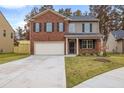 Charming two-story home with a brick and siding facade, attached garage, and well-maintained front lawn at 5441 Flat Rock Point Pt, Stonecrest, GA 30038