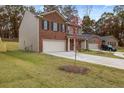 Two-story home featuring a brick and siding exterior, a two-car garage, and a spacious driveway at 5441 Flat Rock Point Pt, Stonecrest, GA 30038