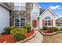 Close-up of the home's entrance, featuring stone accents and a well-manicured garden at 2738 Lakewater Way, Snellville, GA 30039