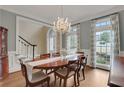 Elegant dining room with a chandelier, wainscoting and large windows at 2930 Monticello Dr, Cumming, GA 30041