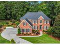 An elevated view of a brick house boasting manicured lawns and a long driveway at 2930 Monticello Dr, Cumming, GA 30041