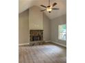 Cozy living room featuring a stone fireplace, ceiling fan, neutral walls and hardwood floors at 8141 Hickory Dr, Covington, GA 30014