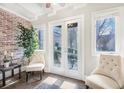 Inviting sun room with French doors, brick accent wall, and natural light at 2840 Peachtree Nw Rd # 301, Atlanta, GA 30305
