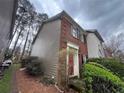 Side view of a charming townhouse featuring brick and siding with a landscaped front yard at 3998 Elm St, Atlanta, GA 30341