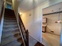Foyer with carpeted stairs and wallpapered walls leading to the kitchen at 3998 Elm St, Atlanta, GA 30341