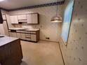Bright kitchen with white cabinets, tile floors, and vintage wallpaper at 3998 Elm St, Atlanta, GA 30341
