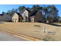 Charming two-story brick and tan home with a manicured lawn and a two car garage at 40 Adler Pl, Covington, GA 30016