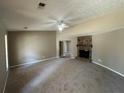 Spacious living room featuring a cozy fireplace and plush carpeting at 5872 Fox Run, Rex, GA 30273