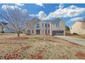 Spacious front yard of brick home with mature tree and long driveway leading to the attached garage at 81 Sheffield Ln, Powder Springs, GA 30127