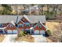 An aerial view of the brick home showcasing its roofline, landscaping, and driveway, with neighboring trees at 2330 Ventana Xing # 10, Marietta, GA 30062