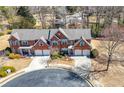 This bird's-eye view highlights the brick home, driveway, and mature trees in its residential setting at 2330 Ventana Xing # 10, Marietta, GA 30062