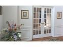 Elegant entryway with white wainscoting, hardwood floors, and French doors leading to another room at 1274 Creek Laurel Dr, Lawrenceville, GA 30043