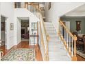 Bright foyer with hardwood floors, staircase with white risers and wood railing leading to the second floor at 1274 Creek Laurel Dr, Lawrenceville, GA 30043